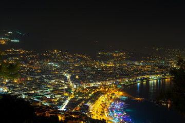 Kizil Kule tower in Alanya bay vith boats and ships, view from peninsula castle, Antalya district, Turkey. Famous tourism destination. Night cityscape.