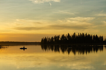 A lone boater on Astotin Lake at Sunset