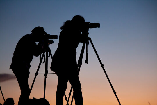 Siluetas  en el atardecer de artistas fot&oacute;grafos con sus c&aacute;maras y tripodes desde la monta&ntilde;a / Silhouettes in the sunset of photographic artists with their cameras and tripods from the mountain 