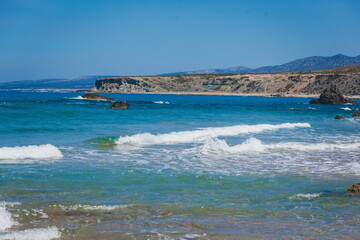 landscape view of a empty sandy beach with the sea and its waves on a nice summer day with blue sky. Cyprus