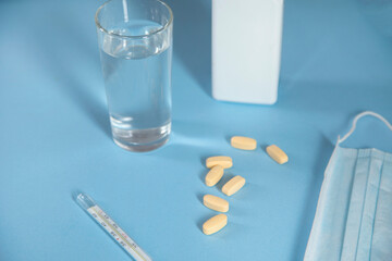 glass of water with drug and thermometer