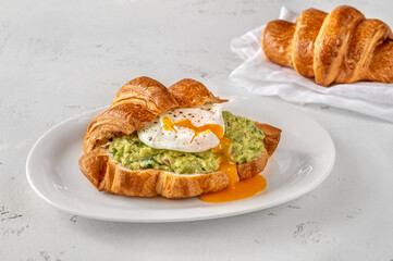 Croissant with guacamole and poached egg