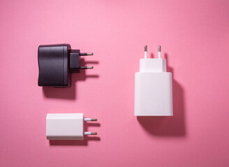 white and black usb charging blocks on a pink background