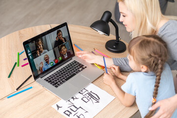 Private lesson. Attentive young woman tutor teacher help little girl pupil with studying math language correct mistakes explain learning material. Smiling mother assist small daughter with home task