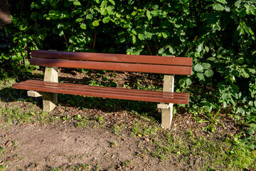 close-up of an empty brown bench by the side of the road 