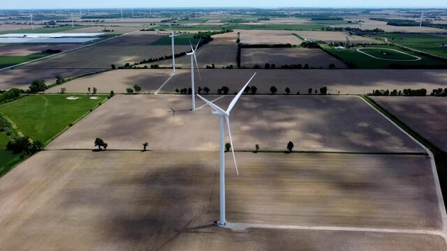Renewable energy being generated by wind turbines on farmland creating sustainable electricity