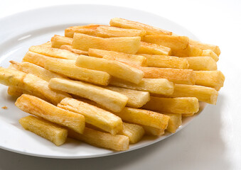 Mandioca frita em palitos no prato em fundo branco para recorte.
