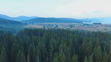 Forests and mountains of the Southern Urals near the village of Tyulyuk in Russia early in the morning. Drone view.