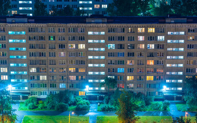 Night colorful windows lights of the high-rise residential building in city sleeping area