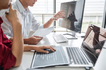 Two professional programmer cooperating and working on web site project in a software developing on desktop computer at company, codes and typing data code, Programming with HTML, PHP and javascript