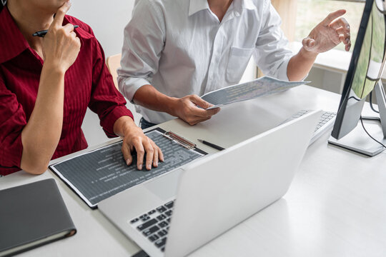 Two professional programmer cooperating and working on web site project in a software developing on desktop computer at company, codes and typing data code, Programming with HTML, PHP and javascript