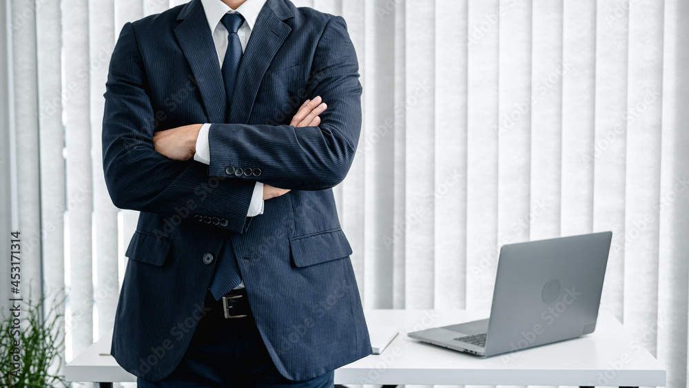 Poster cropped image of businessman in suit standing with arms crossed and feeling confidence in work about
