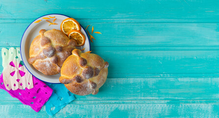 Pan de muerto on blue background, typical mexican food. Day of the dead celebration. Copy space. Top view.