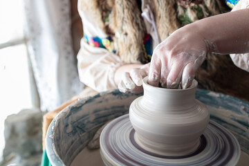 creation of a traditional vase of gray clay on a potter's wheel
