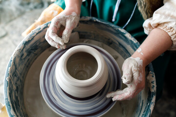 in the pottery workshop works master, dirty hands and a potter's wheel