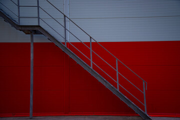 Metal staircase on a red background. Buildings and architecture.