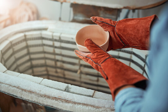 Female potter firing pottery in electric kiln