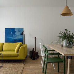 Simple living room with yellow sofa and dining table