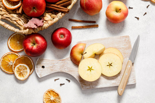 Fresh ripe red apples with knife and chopping board on white table background. Autumn apple flat lay, top view, copy space. Autumn harvest and cooking apple meal, apple pie concept. - Powered by Adobe