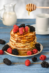 A stack of American pancakes with honey.