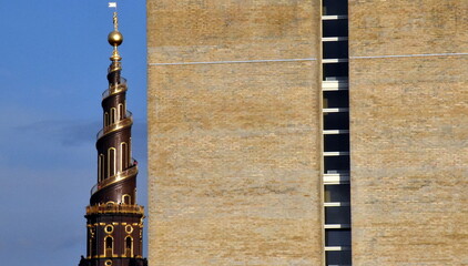 Turm der Erlöserkirche in Kopenhagen neben einer Klinkerfassade