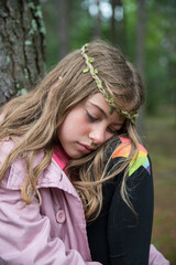 Naklejka premium Sad girl in the woods among the trees.