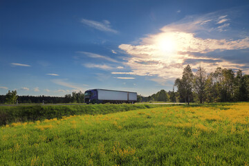 Obraz premium Landscape with a moving truck at sunset 