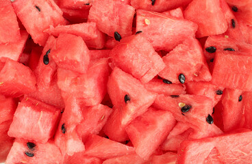 Background of sliced watermelon pieces with seeds. Full frame texture