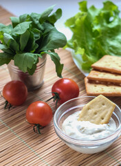 Crispy cracker with herbs and cherries. Still life of eating cookies with sauce and herbs and tomatoes.