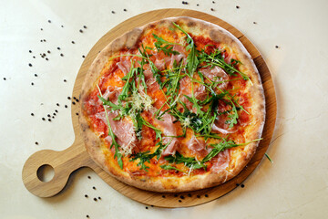 Italian fast food. Delicious hot pizza with sliced meat cheese and herbs served on wooden table with ingredients, top view. Menu photo.