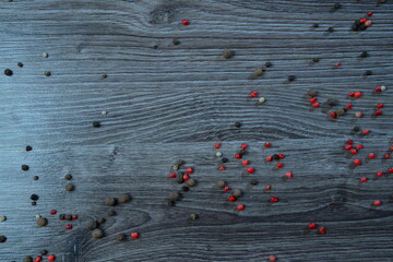 dark wooden texture and scattered spices on it. Top view on with pepper and salt