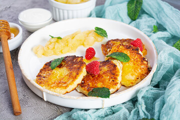 Curd cheese pancake with sour cream, honey and berries. Delicious syrniki with caramelized pears