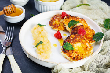 Curd cheese pancake with sour cream, honey and berries. Delicious syrniki with caramelized pears