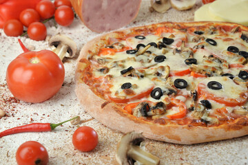 pizza with mushrooms olives and cheese. served on wooden table with ingredients