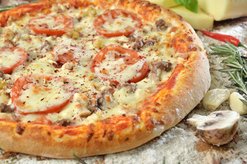 meat pizza with cheese tomato and mushrooms on wooden table with ingredients background.top view