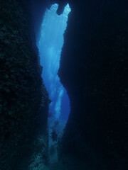 cave diving underwater scuba divers exploring caves and arches ocean scenery sun beams and rays background
