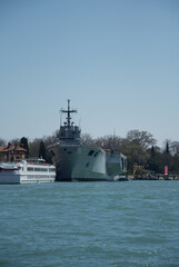 Obraz premium buildings, boats and the anchored military ship near canals in Venice,Italy, 2019