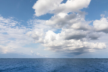 Naklejka na ściany i meble Sea and blue sky with clouds