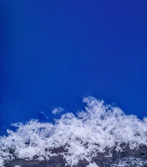 Snowflakes on a blue background. Snow on a large scale. Snow background. Vertical