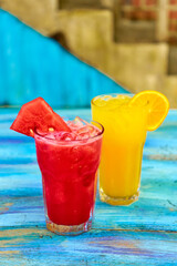 Obraz premium Two glass glasses with refreshing drinks from orange and watermelon juice.