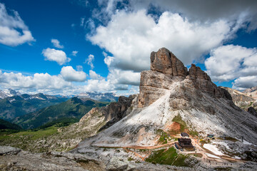 Fototapeta na wymiar spring panorama of the green meadows of the Dolomites with snow and pink rocks at the Falzarego pass in Cortina d'Ampezzo Belluno Italy