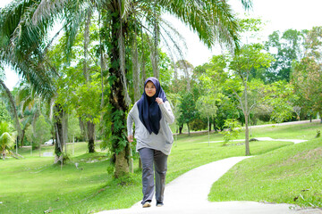 Portrait of a young muslim woman exercising and jogging outside in the park