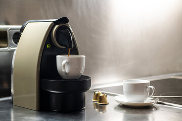 Preparing capsule coffee in a machine in a kitchen of a vacation rental apartment