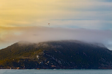 extreme sport, paraglider flying over the clouds at sunset at Praia dos Ingleses and Santinho, in the city of Florianópolis, Brazil