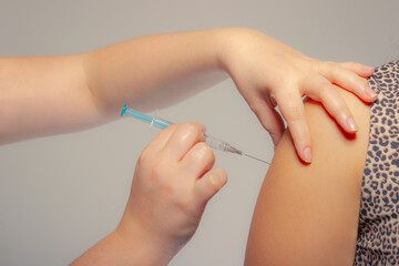 Selective focus, woman injecting vaccine to patient.