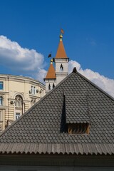 Close-up of ancient gray wooden tiled roof of historical stone building. Old wooden mosaic shingles on the roof.  Example of mediavial wooden russian style architecture.