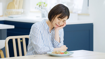食事中に考え事をする若い女性