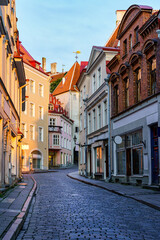 Fototapeta na wymiar Narrow alley of medieval houses in the city of Tallinn at sunrise. Estonia.