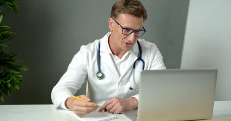 Handsome Male Doctor Working with Laptop at Video Conference with Distant Patient Using Virtual Chat Online. Remote Consultation Medic Professional Smiling Telemedicine Computer App Video Call Concept