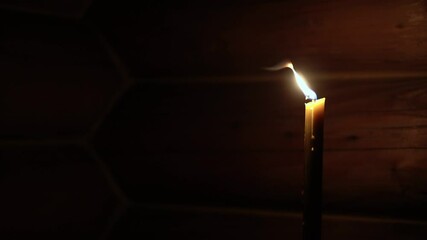 Religion, holidays, concept - Panning along rays of light from window in smoky dusty room falling on altar throne in Christian Orthodox temple with burning candle lamp nearby menorah under chandelier.